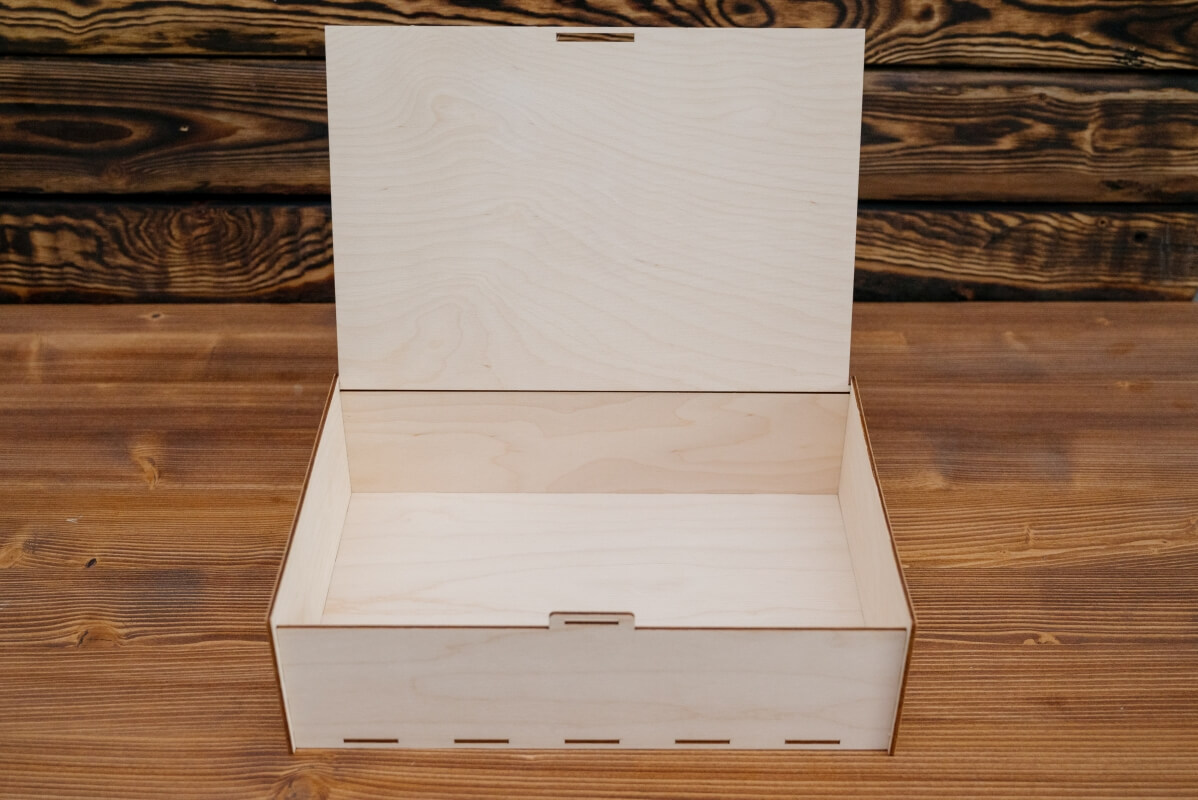 Otwarta drewniana skrzynka na stole, przykład produktów ze sklejki.