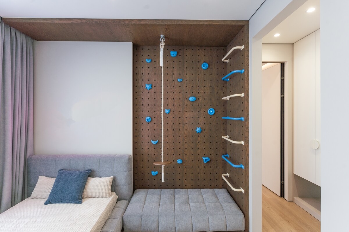 Domowy kącik z łóżkiem i ścianką wspinaczkową ze sklejki.